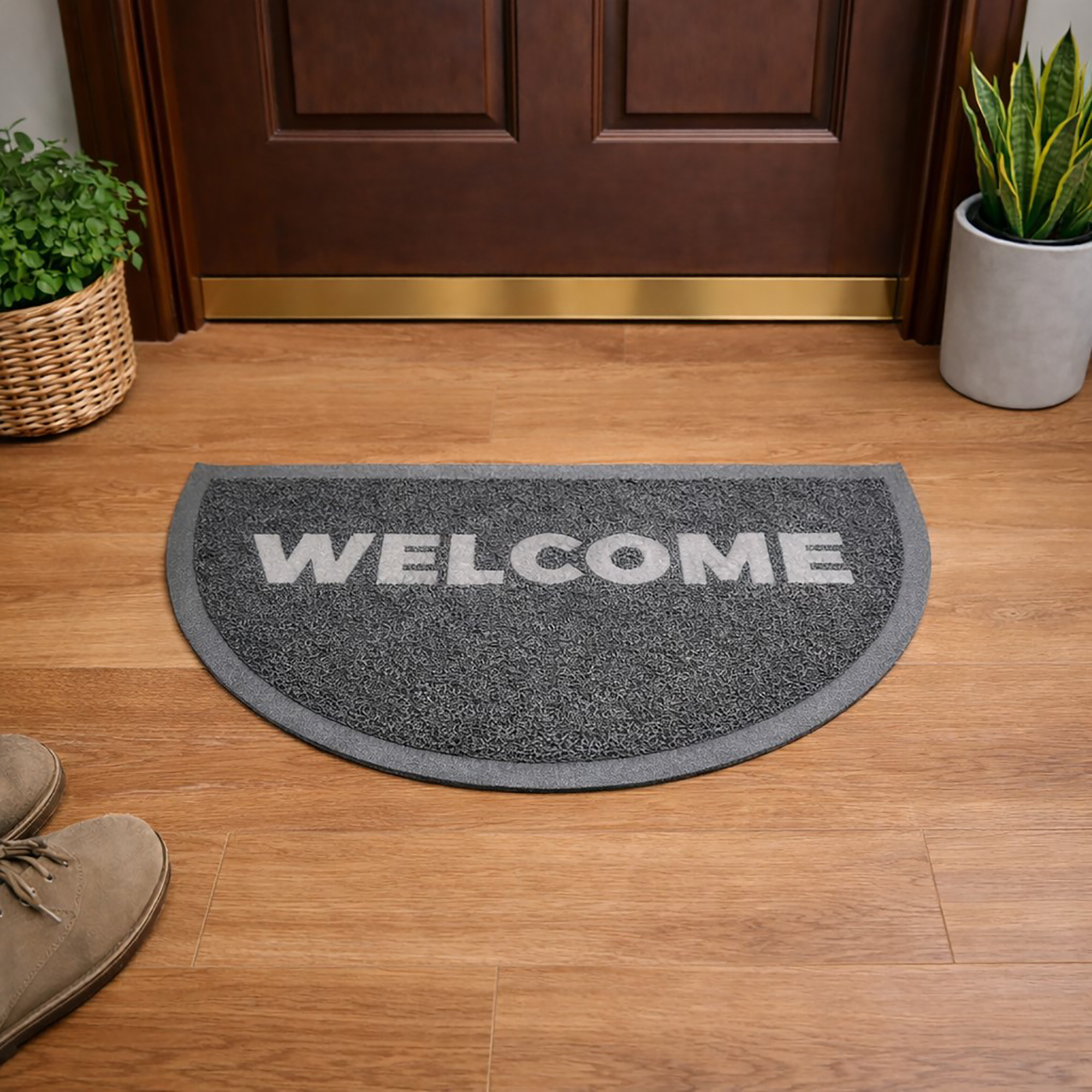 Indoor entryway with gray semi circle welcome doormat in front of wooden door
