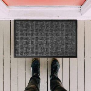 Top view of gray checkerboard doormat with feet for scale