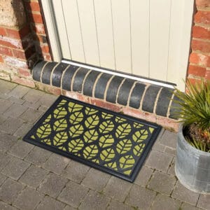 Green leaf design doormat placed in front of an exterior door