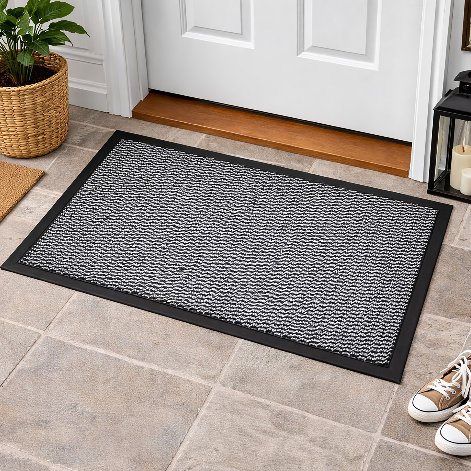 Gray indoor door mat placed in front of white entry door on tile floor