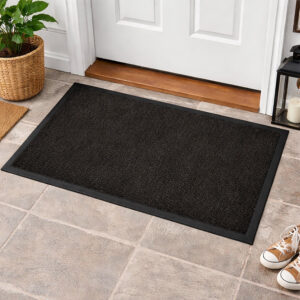 Black indoor door mat placed in front of white entry door on tile floor