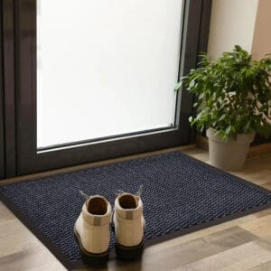 Blue entry door mat with rubber border placed indoors with shoes