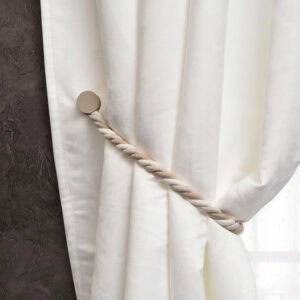 Single beige braided tieback with round magnetic clasp on white curtain