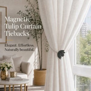 lifestyle: Black resin tulip magnetic tieback holding a flowing sheer curtain beside a sunlit window in a bright neutral living room.