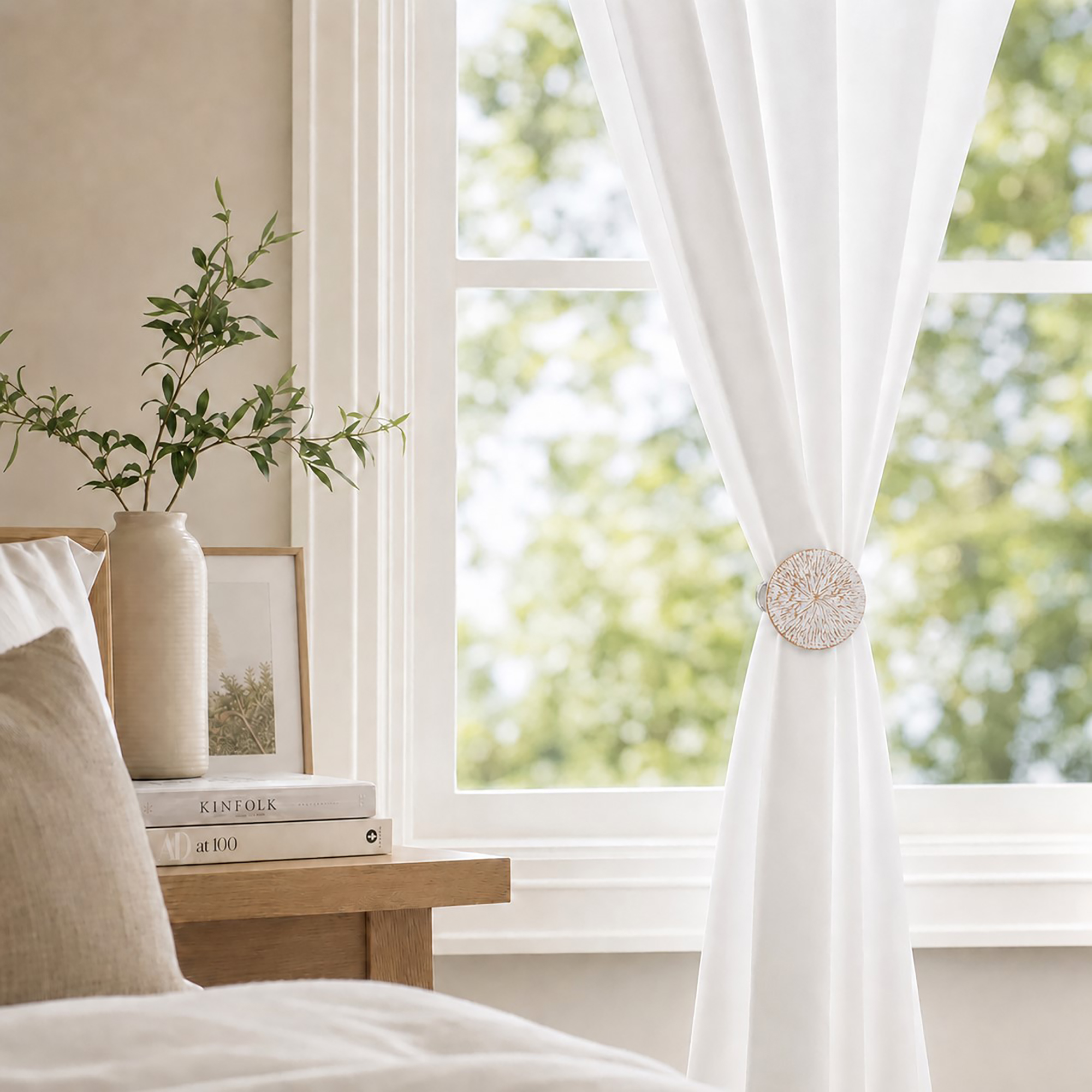 White and gold round curtain tieback clip holding back white drapes in a room