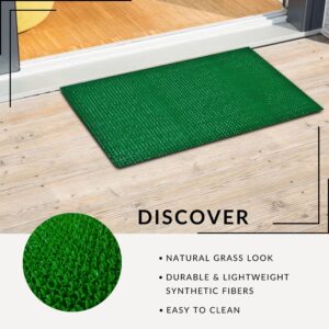 Green grass look doormat at entryway showing textured synthetic fibers