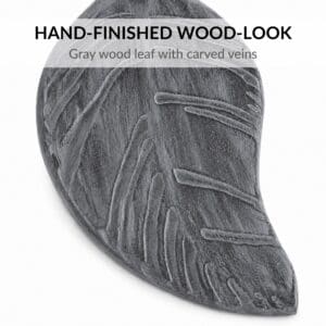 Close-up of gray brushed wood-look leaf tieback with carved veins and brushed finish