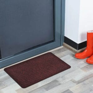 Maroon indoor door mat placed in front of a modern entry door