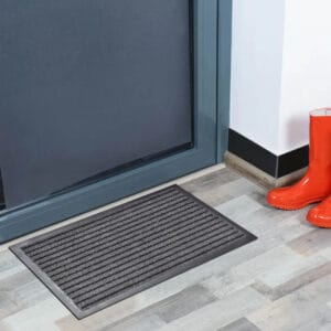 Gray striped indoor door mat on modern floor near entry door