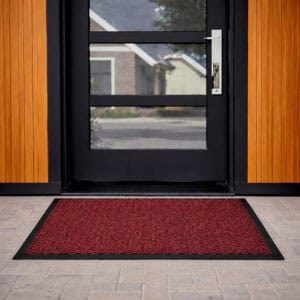 Red door mat in front of modern glass exterior door