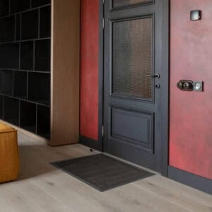 Black door mat fitting easily under front door