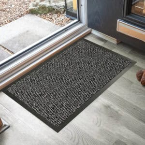 Gray indoor outdoor doormat placed by sliding door on wood floor