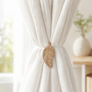 Natural wood leaf magnetic tieback holding back a light linen curtain by a window