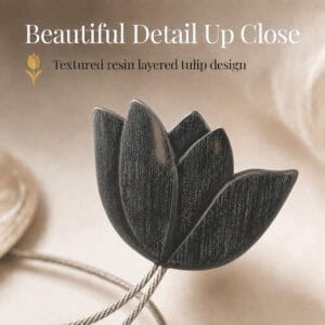 texture detail: Macro view of the layered resin tulip in black, showing the textured petals and brushed finish of the curtain tieback flower.