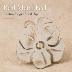 Close up of the textured rigid metal on an ivory and gold floral curtain tieback