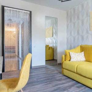 Bamboo beaded curtain installed in modern living room with yellow sofa