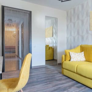 Bamboo beaded door curtain in modern living room with yellow sofa