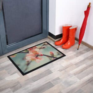 Flower print indoor doormat placed near door with boots and umbrella