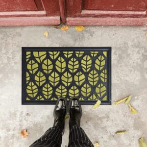 Green leaf pattern doormat seen from above with feet for scale