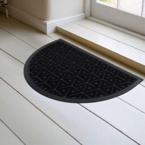 Black half moon door mat placed inside entryway on light floor