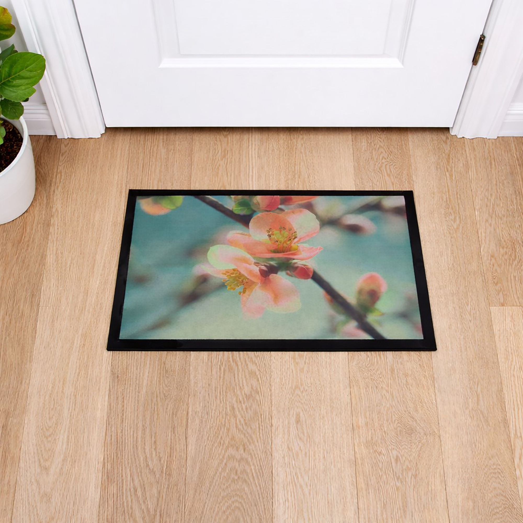 Top view of rectangular indoor flower doormat on wooden floor