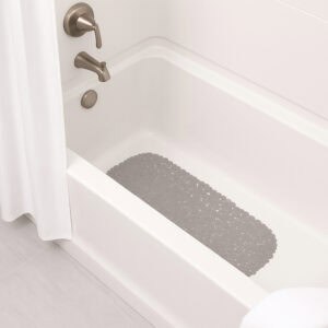 Taupe bath mat placed in white bathtub with brushed nickel fixtures