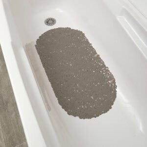 Overhead view of taupe bubble-pattern bath mat in white bathtub near drain