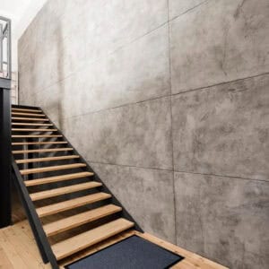 Blue entryway floor mat placed at stair landing in modern interior