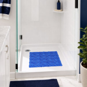Navy blue shower mat with suction cups inside a tiled shower stall