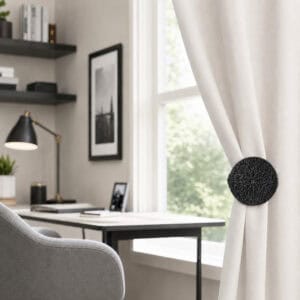Black round curtain tieback clip in an office setting