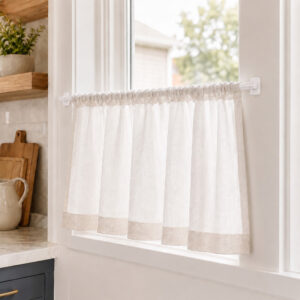 Sheer cafe curtain on an adhesive sash rod in a bright farmhouse kitchen window