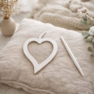 "White wooden heart frame and pin displayed on linen cushion"