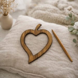 "Dark natural wood heart frame and pin displayed on linen cushion"
