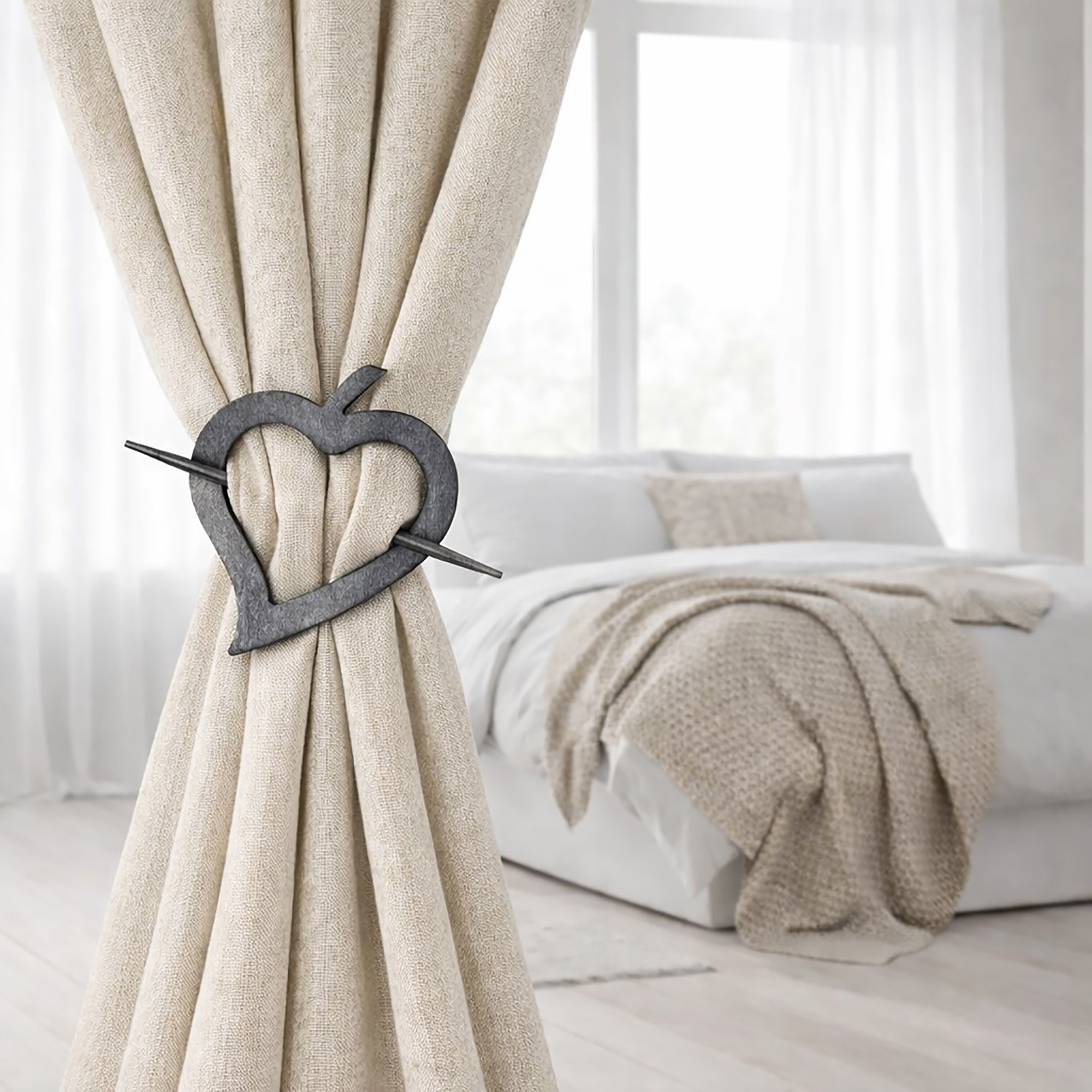 "Gray wood heart tieback on linen drape in minimalist bedroom"