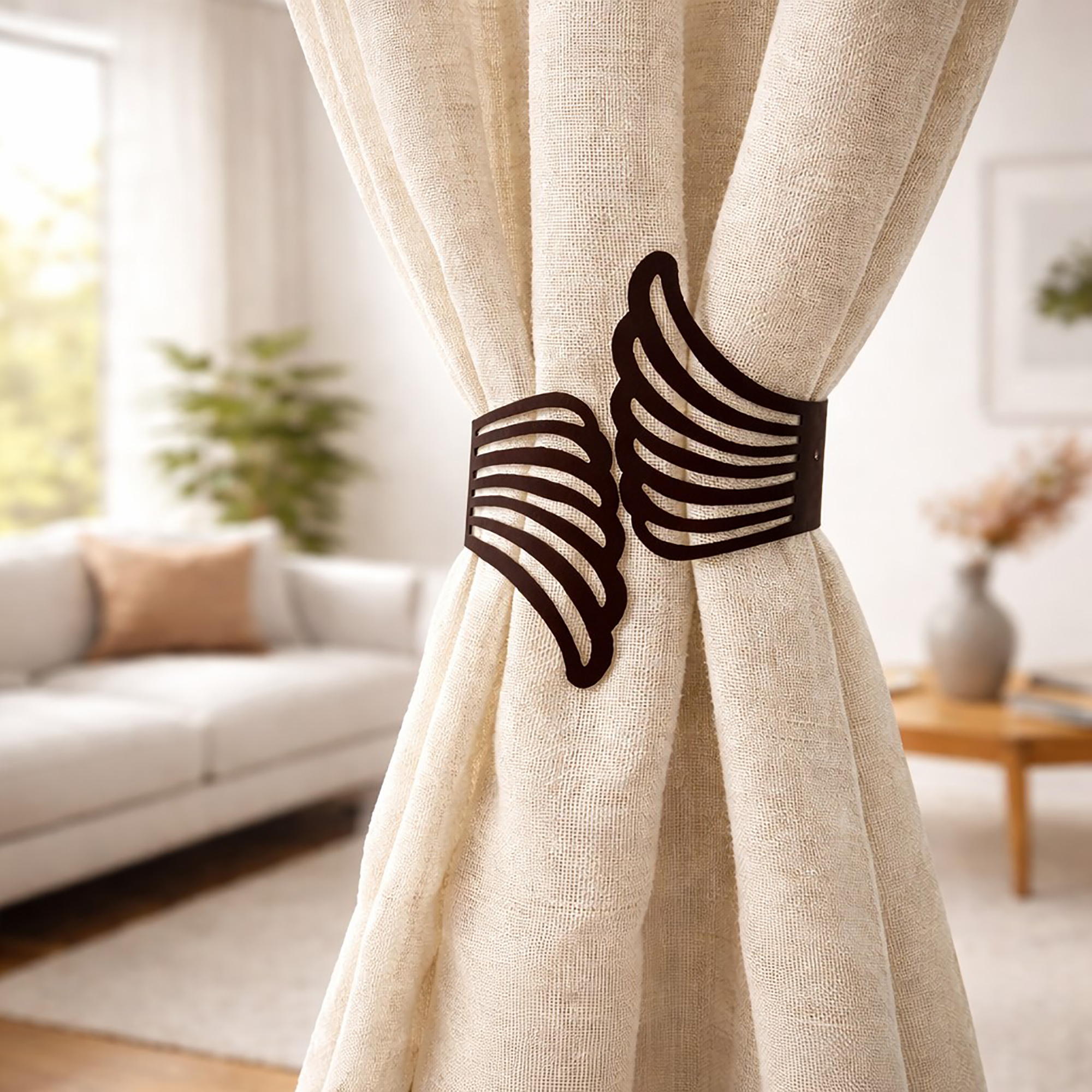"Black metal wings tieback holding cream curtains in a modern living room"