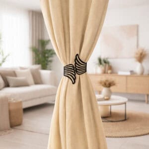 "Black angel wings curtain tieback on beige drapes in a Scandinavian-style living room"