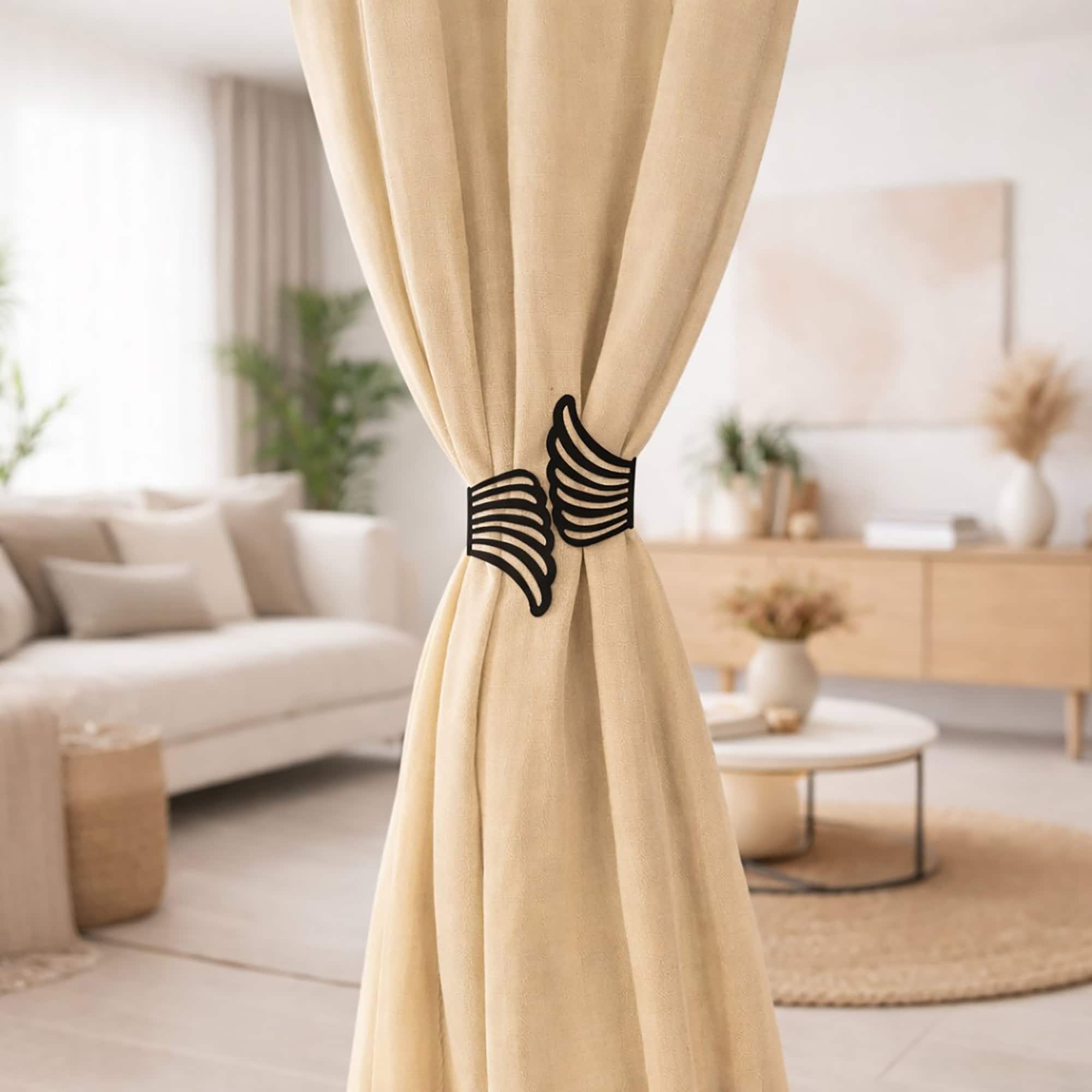 "Black angel wings curtain tieback on beige drapes in a Scandinavian-style living room"
