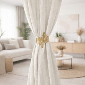 "Gold angel wings curtain tieback on white drapes in a Scandinavian-style living room"