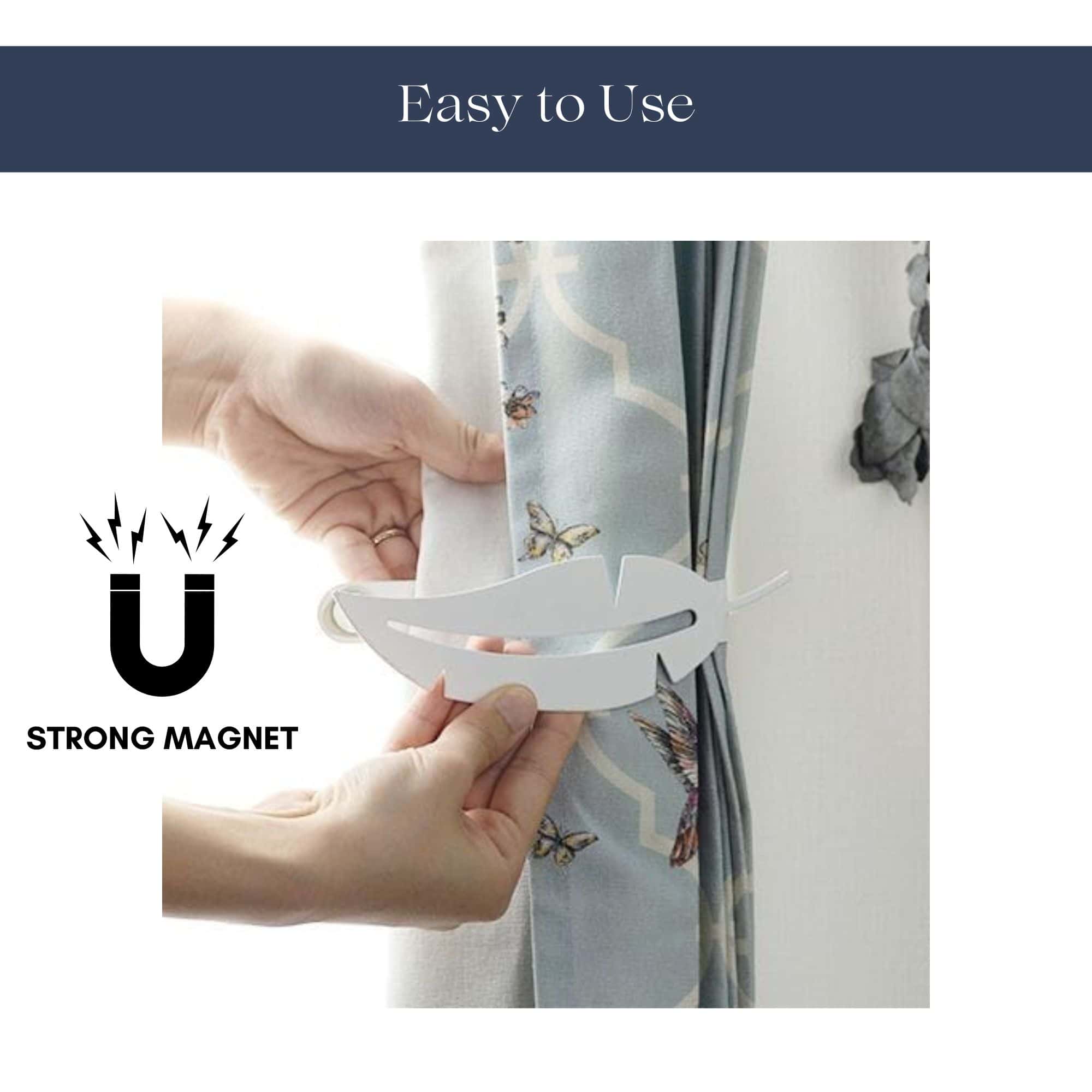 "Hands demonstrating magnetic closure of white feather curtain tieback"