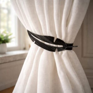 "Black feather metal tieback holding white curtain against wall"