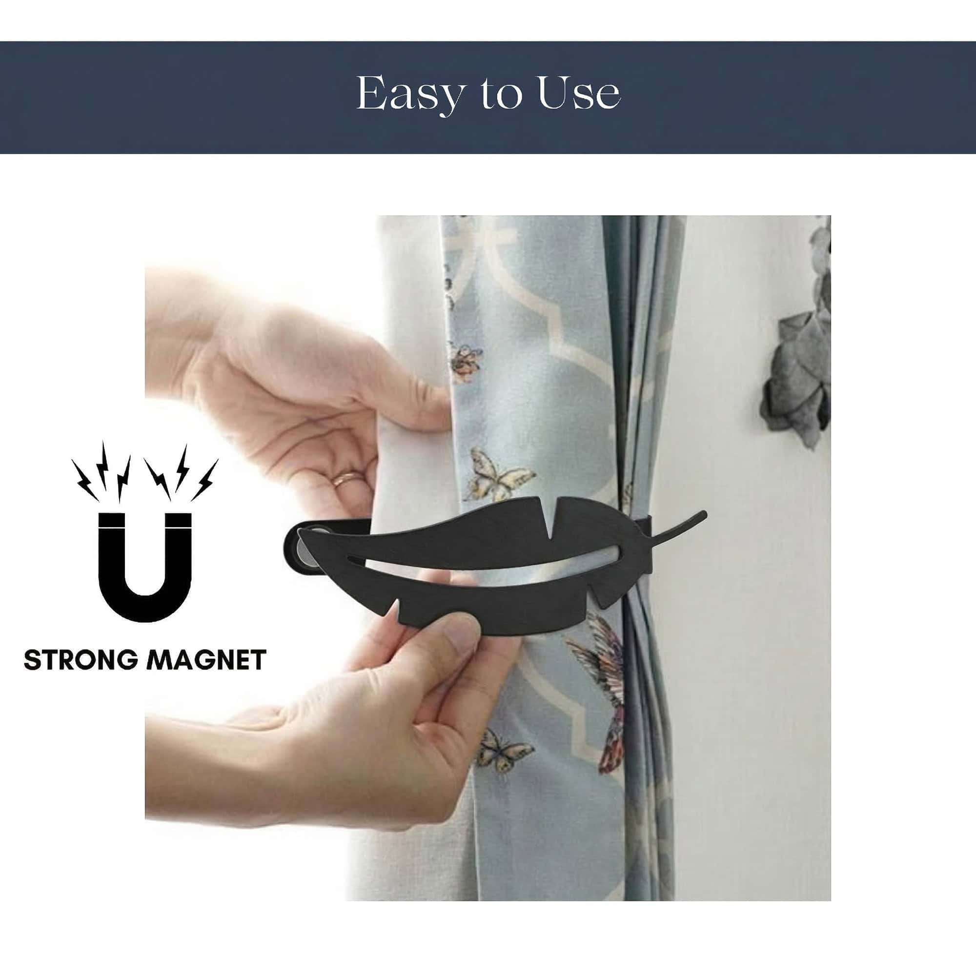 "Hands demonstrating magnetic closure of black feather curtain tieback"