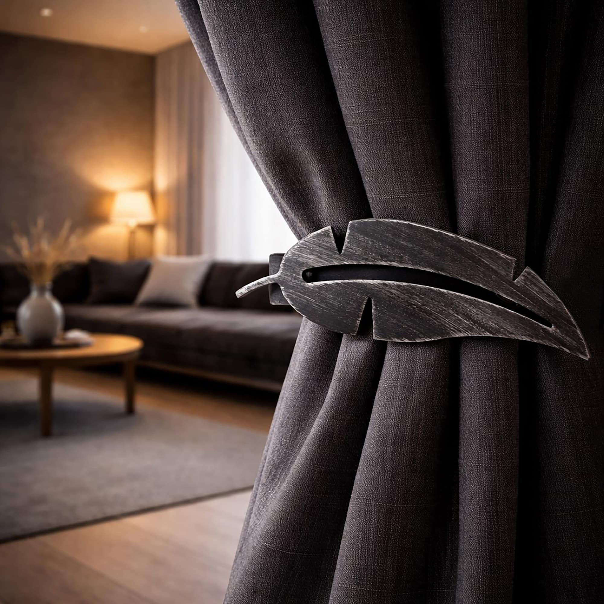 "Black brushed metal feather tieback on dark grey curtain in moody living room"