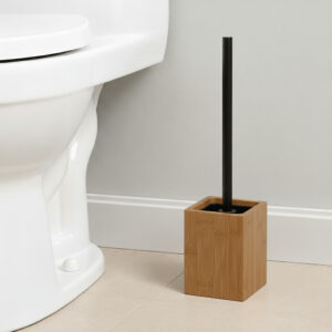 Wooden toilet brush with black handle in square acacia holder next to white toilet
