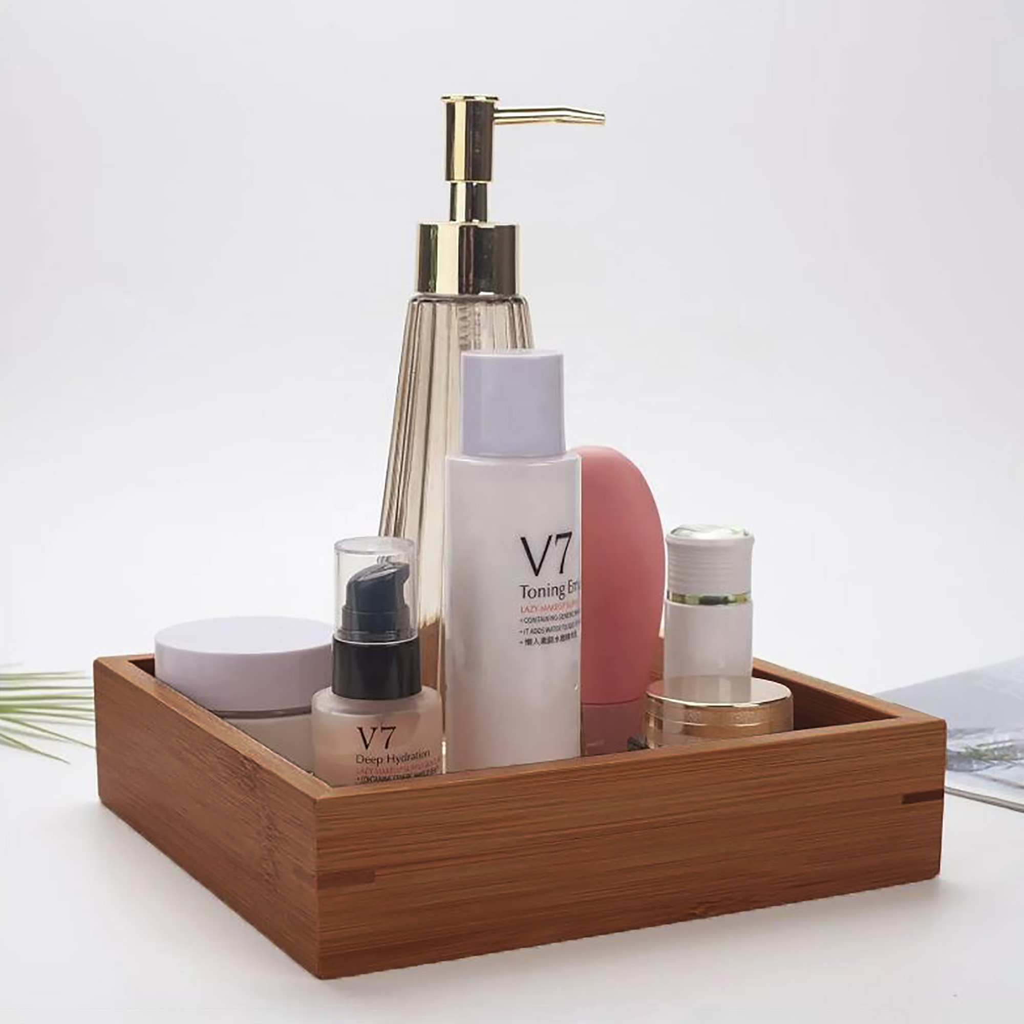 A wooden tray holding skincare bottles and beauty products.