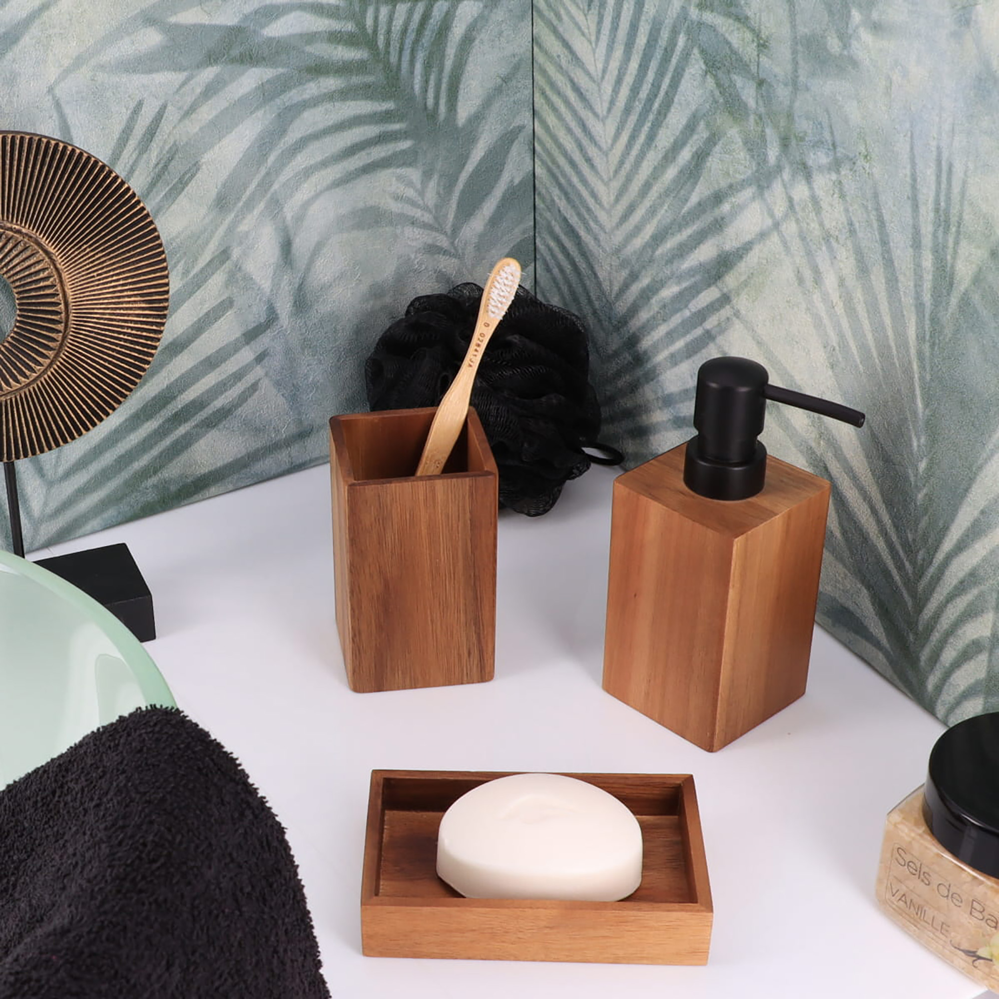 A wooden bathroom set with a toothbrush holder, soap dispenser, and soap dish in a stylish setting.