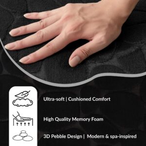 Hand pressing into the soft surface of a black runner mat with pebble pattern showing cushioned comfort and memory foam features