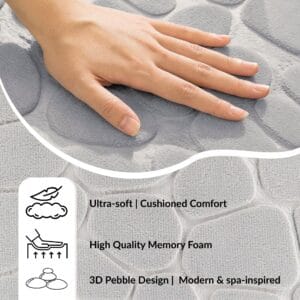 Hand pressing into the soft surface of a light gray runner mat with pebble pattern showing cushioned comfort and memory foam features