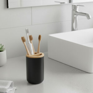 Black toothbrush holder with bamboo top on bathroom counter