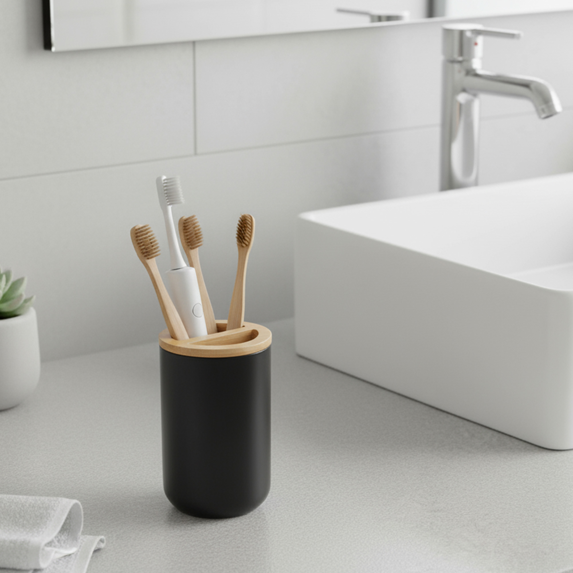 Black toothbrush holder with bamboo top on bathroom counter