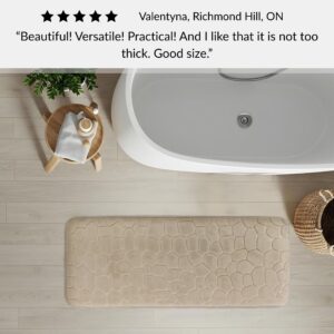Taupe memory foam runner mat placed beside bathtub in spa-style bathroom with customer review highlighting versatility and size